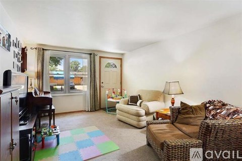 A living room with a brown wicker couch and a white sofa.