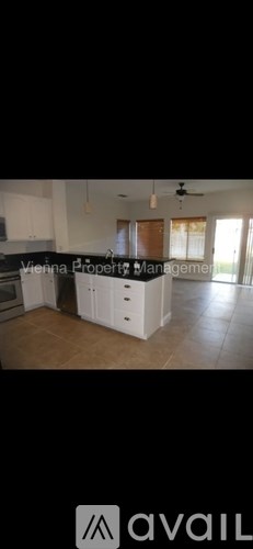 A kitchen with white cabinets and a tiled floor.
