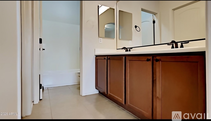 A bathroom with brown cabinets and a white door.