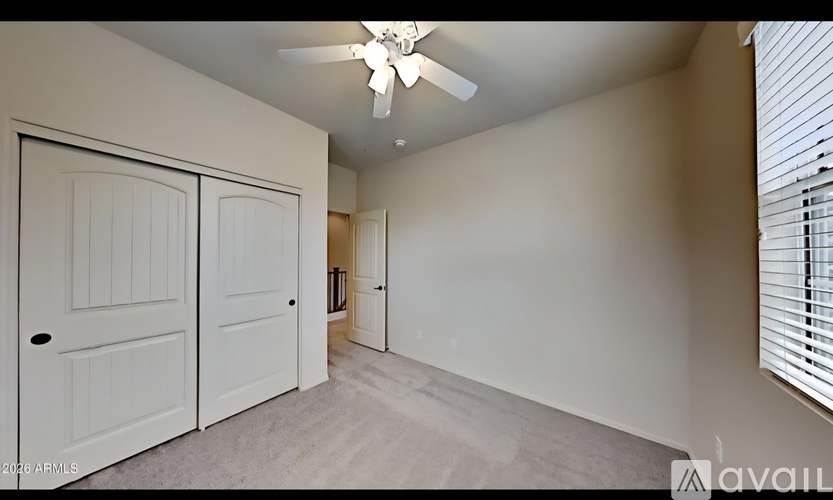 A room with a ceiling fan and two doors.