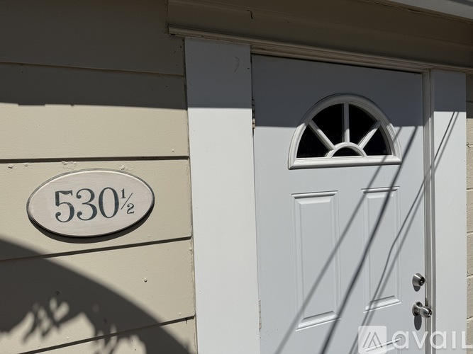 A white door with a window above it and a sign that says 530 on the wall.