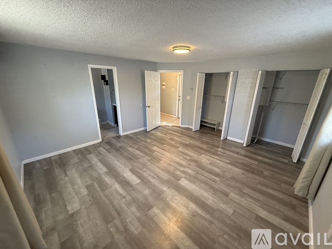 A room with wooden flooring and white walls.