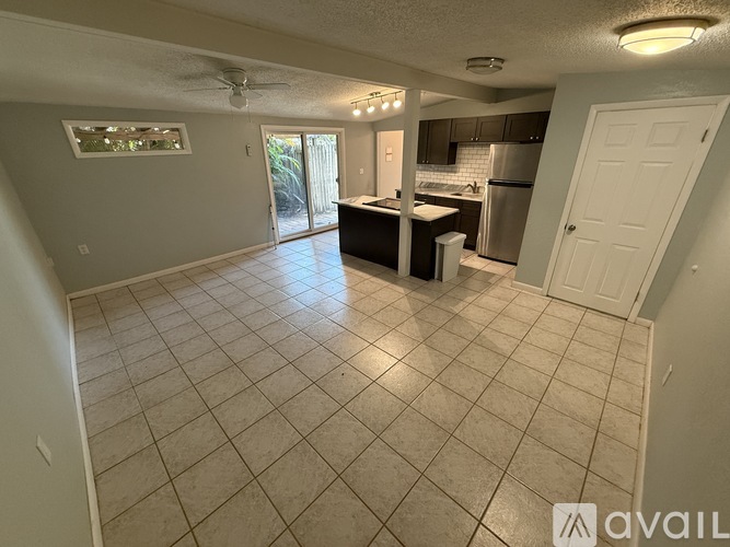 A kitchen with tile flooring and a ceiling fan.