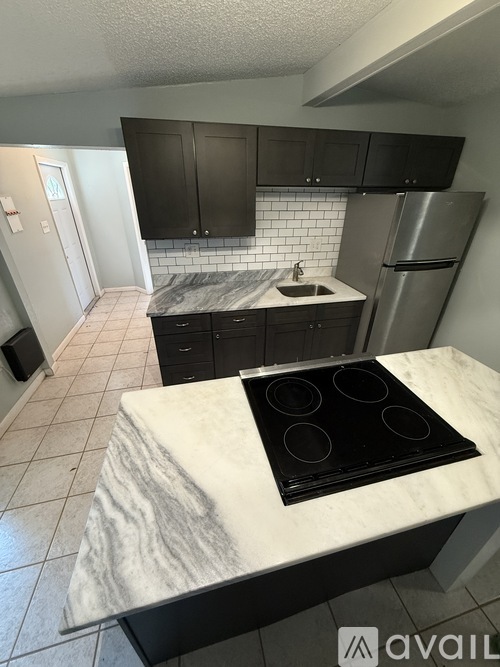 A kitchen with a marble countertop and stainless steel appliances.