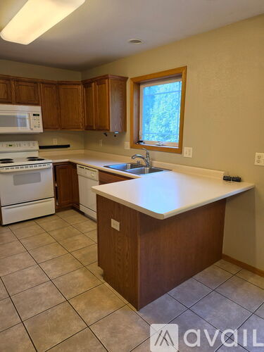 A kitchen with wooden cabinets and a white countertop.
