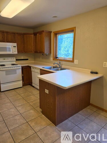 A kitchen with wooden cabinets and a white countertop.
