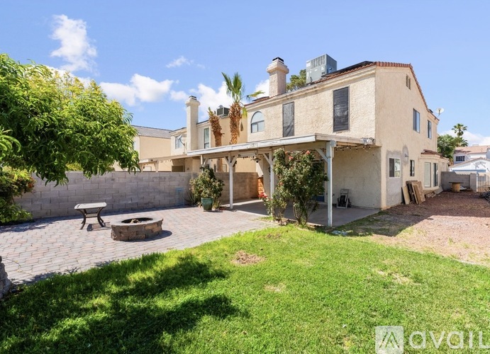A house with a patio and a tree in front.