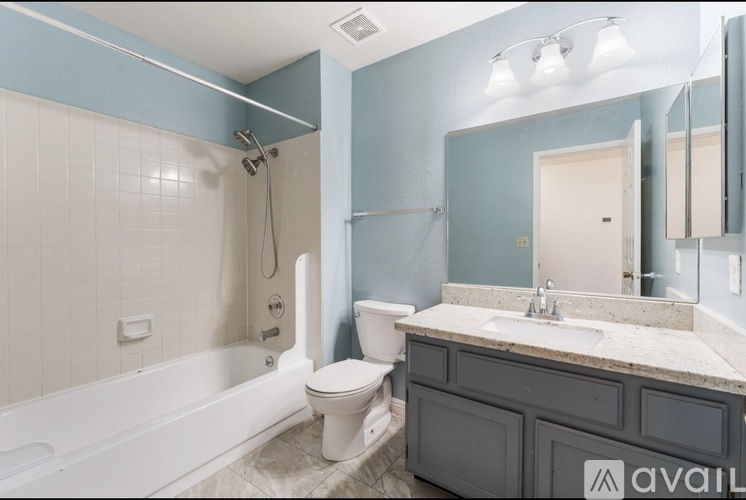 A bathroom with a blue wall and a white bathtub.