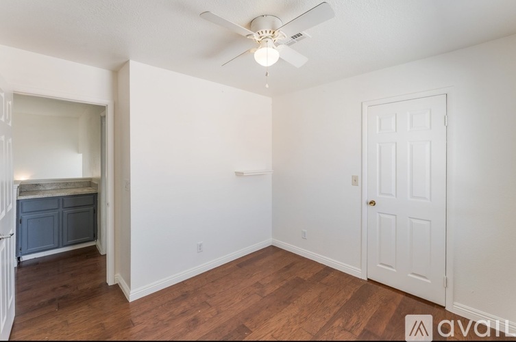 A room with a ceiling fan and a door.