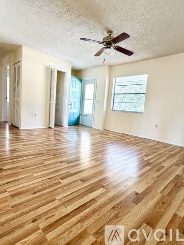 A room with wooden flooring and a ceiling fan.