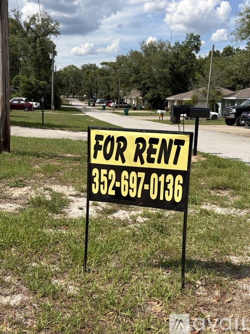 A "FOR RENT" sign with a phone number is displayed in a grassy area.