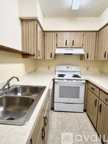A kitchen with a white stove and a sink.