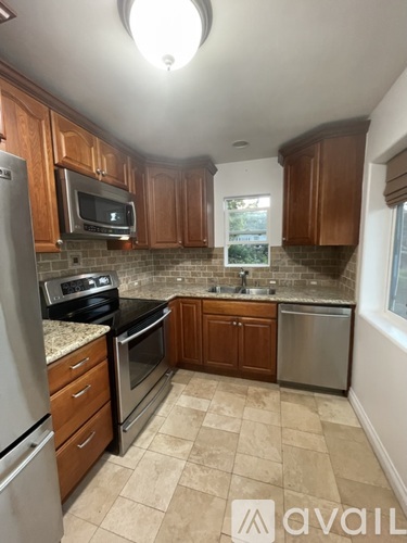 A kitchen with wooden cabinets and a tiled backsplash.