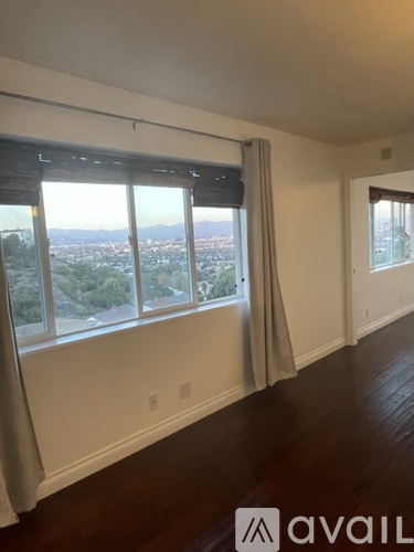 A room with a large window overlooking a cityscape.