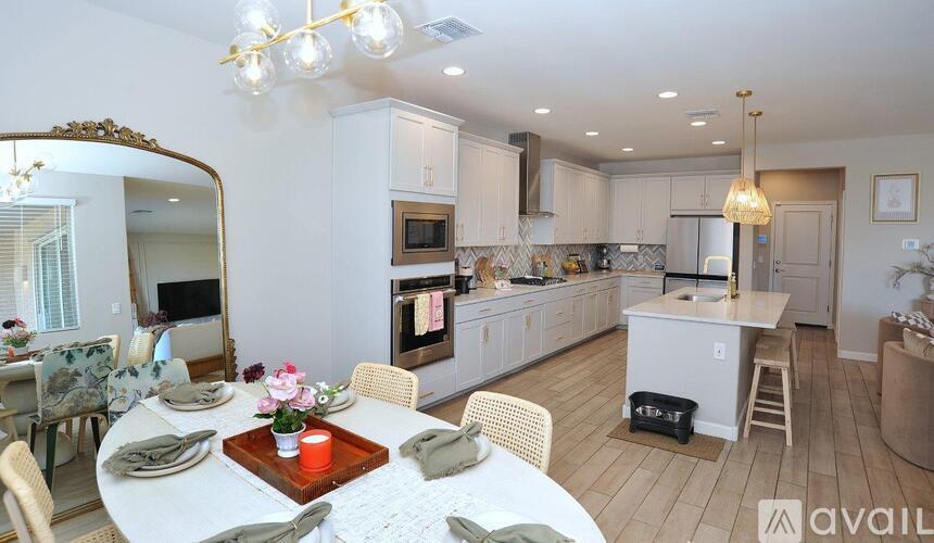 A well-lit kitchen with a dining table set for two.