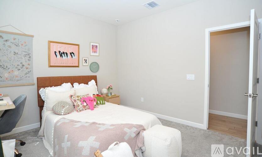 A bedroom with a bed, chair, and pictures on the wall.