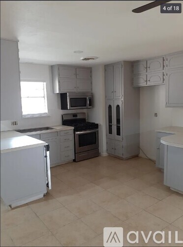 A kitchen with white cabinets and appliances.