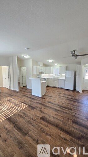 A kitchen with white cabinets and a wooden floor.