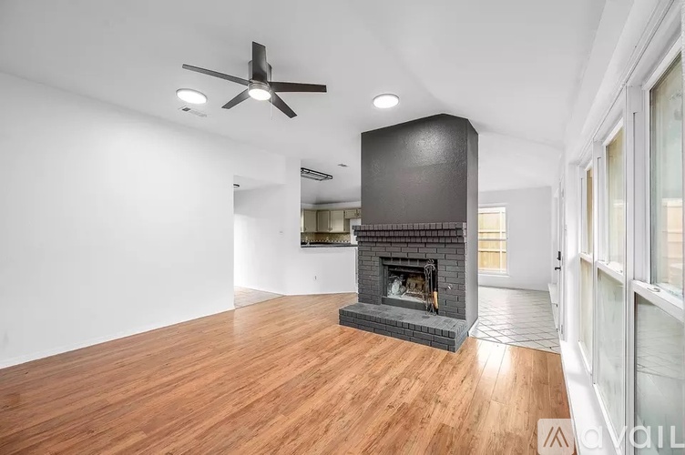 A modern living room with a fireplace and wood flooring.
