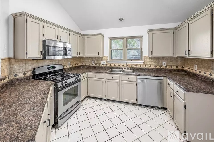 A kitchen with a black stove top oven and white cabinets.