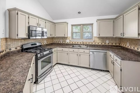 A kitchen with a black stove top oven and white cabinets.