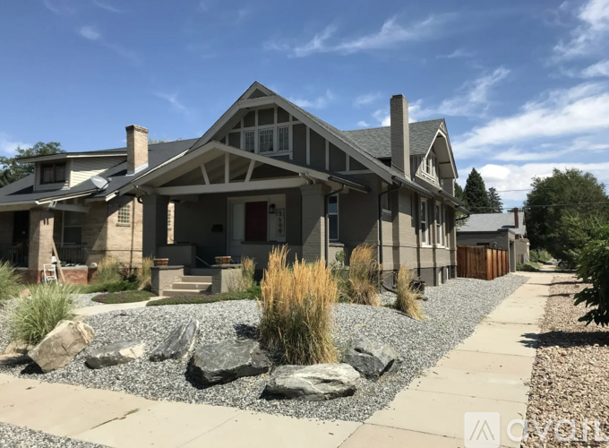 A house with a grey roof and a gravel garden in front.