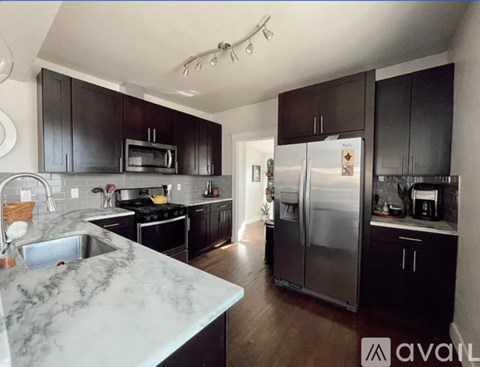 A kitchen with a marble countertop and stainless steel appliances.
