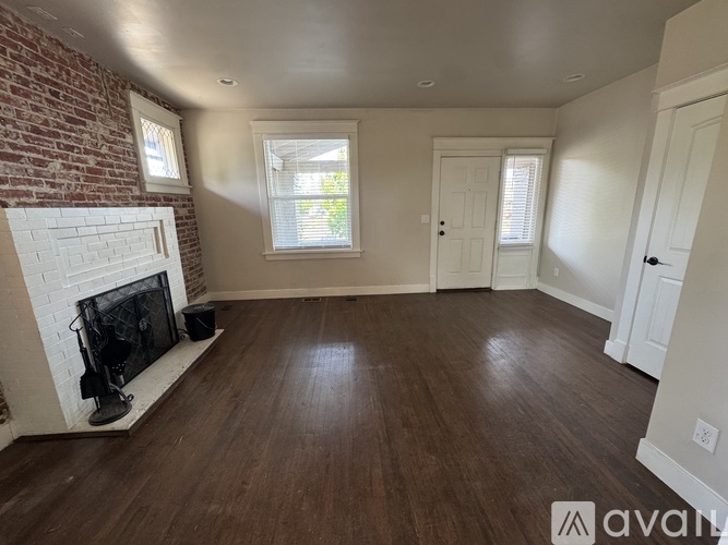 A room with a fireplace and wooden floors.
