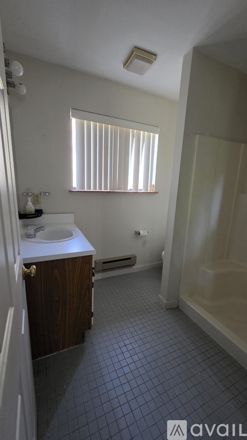 A bathroom with a sink, mirror, and tiled floor.