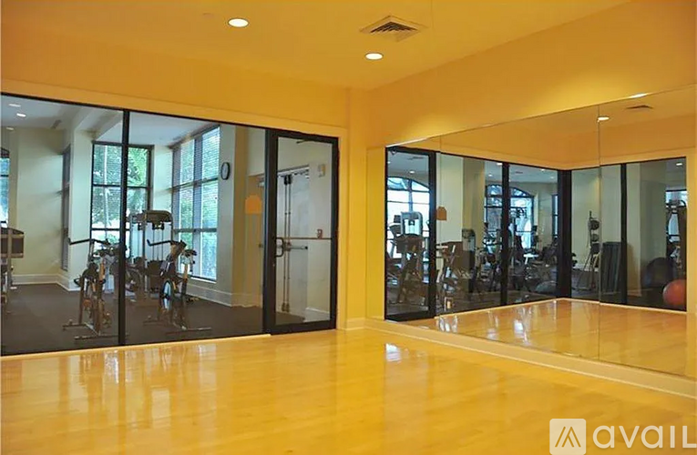 A spacious room with wooden floors and glass doors leading to a balcony.
