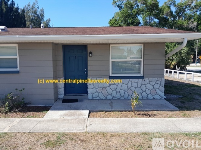 A house with a blue door and a small tree in front.