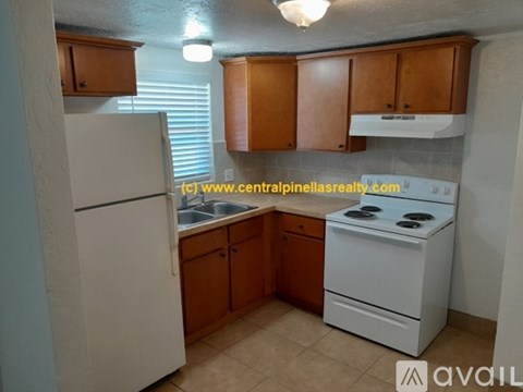 A kitchen with wooden cabinets and white appliances is available for rent.