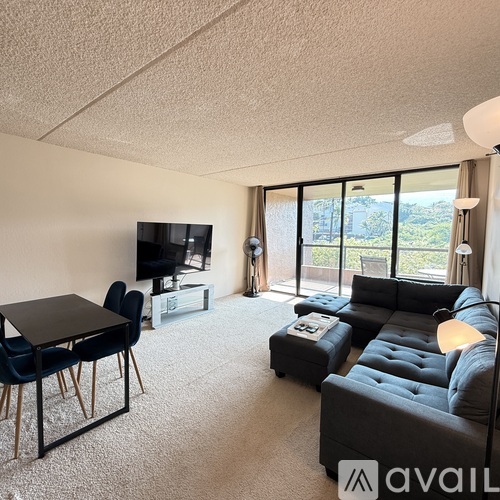 A living room with a grey couch, a black table, and a television.