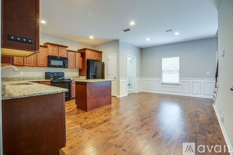 A kitchen with wooden cabinets and a granite countertop.