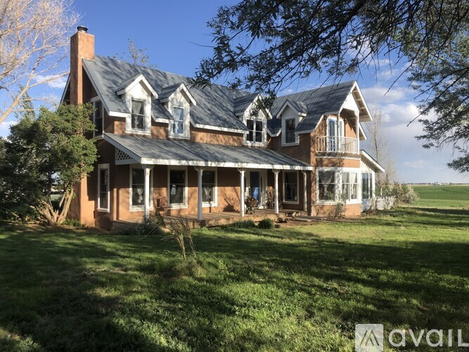 A large, well-maintained house with a brick exterior and a large front porch.