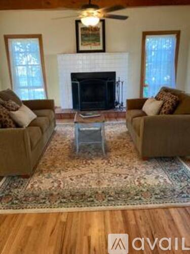 A living room with a fireplace and two couches.