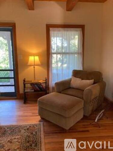 A living room with a chair, a lamp, and a window.