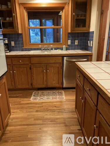 A kitchen with wooden cabinets and a window above the sink.