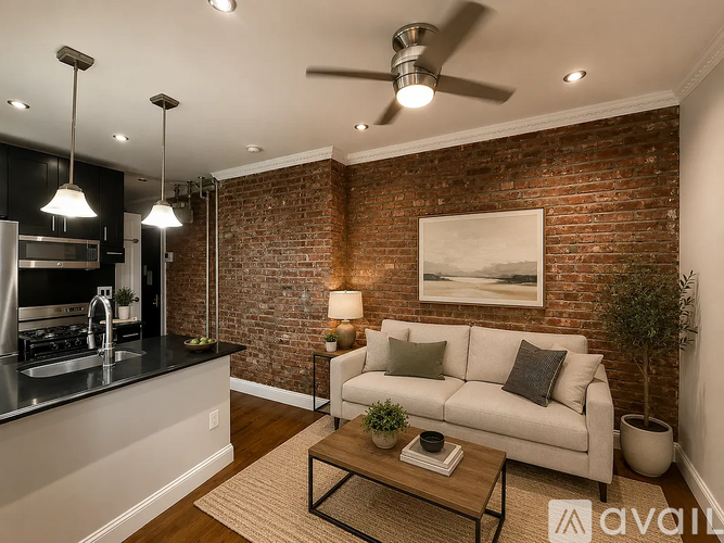 A modern kitchen with a brick wall and a white couch.