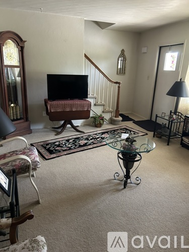 A living room with a glass coffee table and a television.