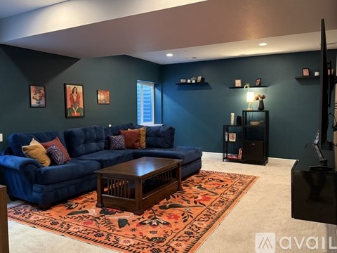 A living room with a blue couch and a rug.