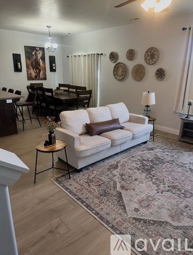 A living room with a white couch and a rug.