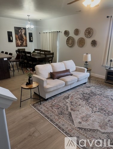 A living room with a white couch and a rug.