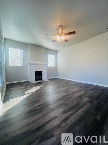A room with a fireplace and wood flooring.