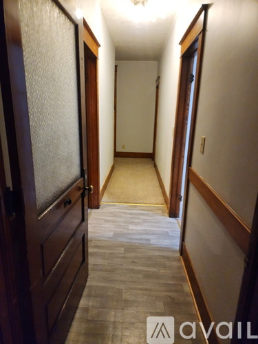 A hallway with wooden doors and a tiled floor.