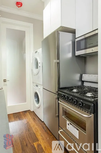 A kitchen with a stove, oven, microwave, and washing machine.