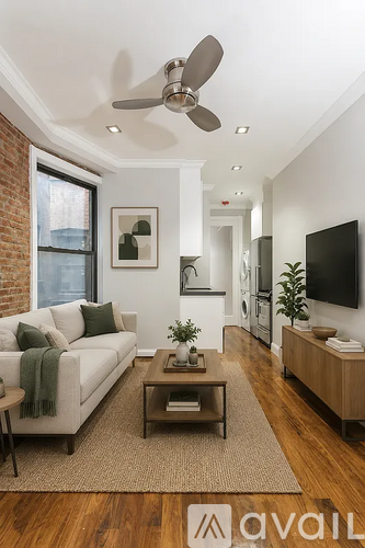 A living room with a white couch and a green throw blanket.