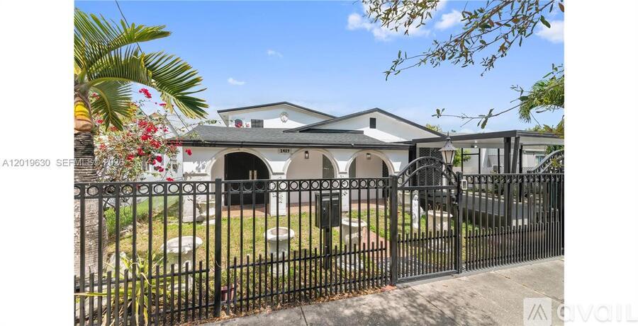 A white building with a black fence in front of it.