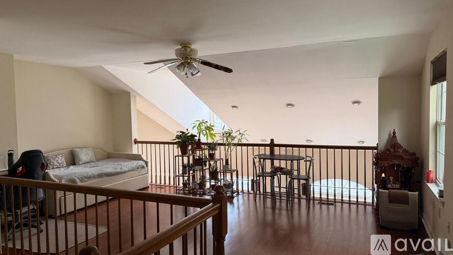 A living room with a couch, a chair, a table, and a ceiling fan.