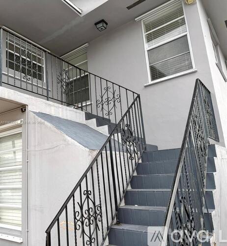A staircase with a metal railing and steps leading up to a window.